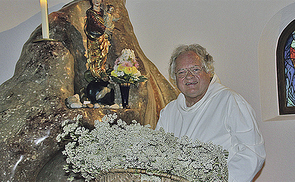 Maria Himmelfahrt: P. Johannes Pausch bringt Schafgarben vor die Marienstatue in der Kirche des Klosters Gut Aich.